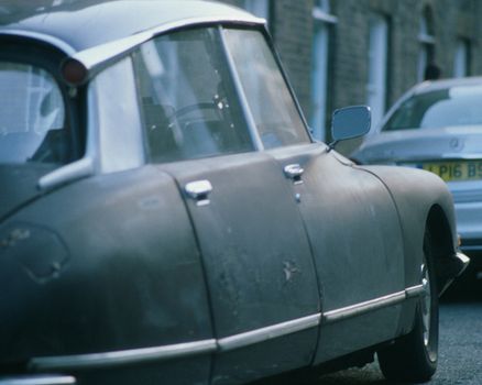 A car is parked on the street next to a building