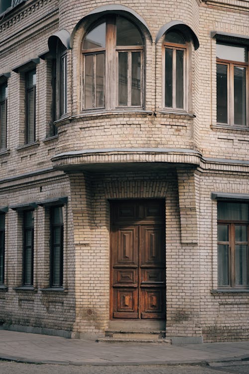 Old Wooden Double Doors in the Entrance on the Corner of a White Brick Building