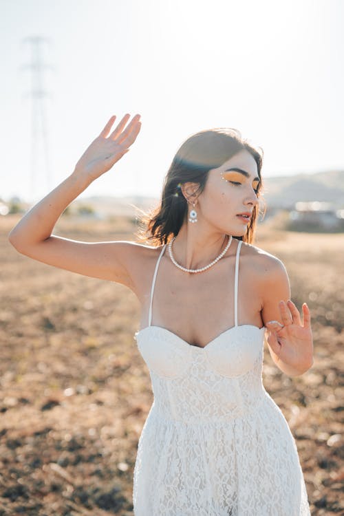 Young Woman in a White Spaghetti Strap Mini Dress and a Pearl Necklace