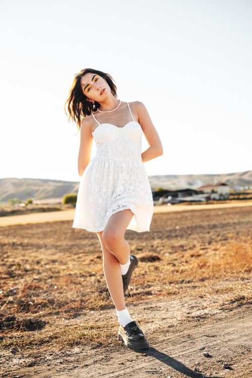 Woman in White Lace Mini Dress Posing on a Field  Free Stock Photo