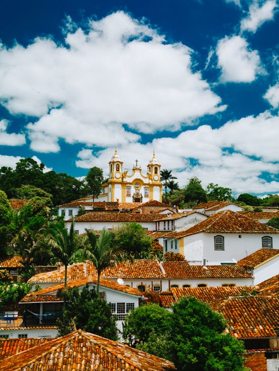 Free A scenic view of Tiradentes showing the Mother Church of Saint Anthony and terracotta rooftops under a blue sky. Stock Photo
