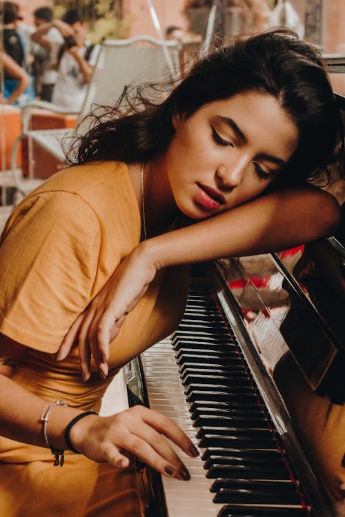 피아노에 그녀의 머리를 누워있는 여자