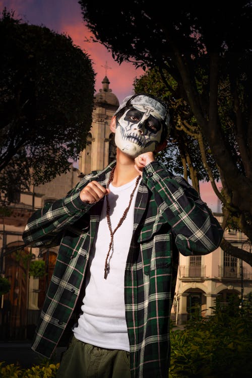 Young Man in Casual Clothes and Face Painting for the Day of the Dead Standing Outside 