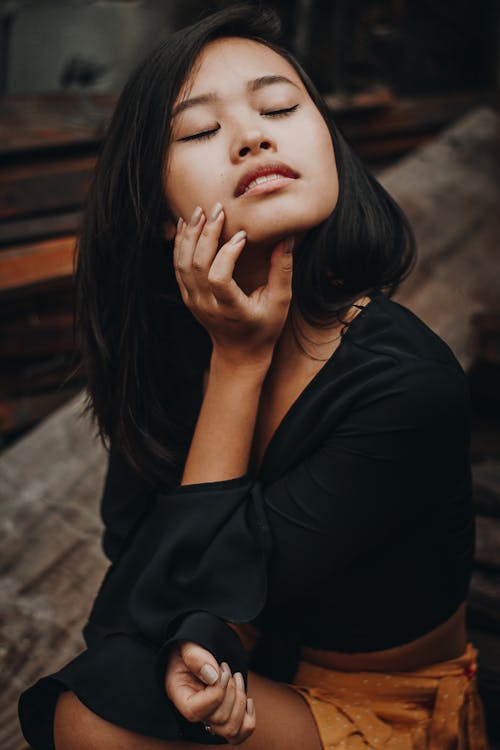 Free Woman Holding Her Chin While Closing Both Eyes Stock Photo