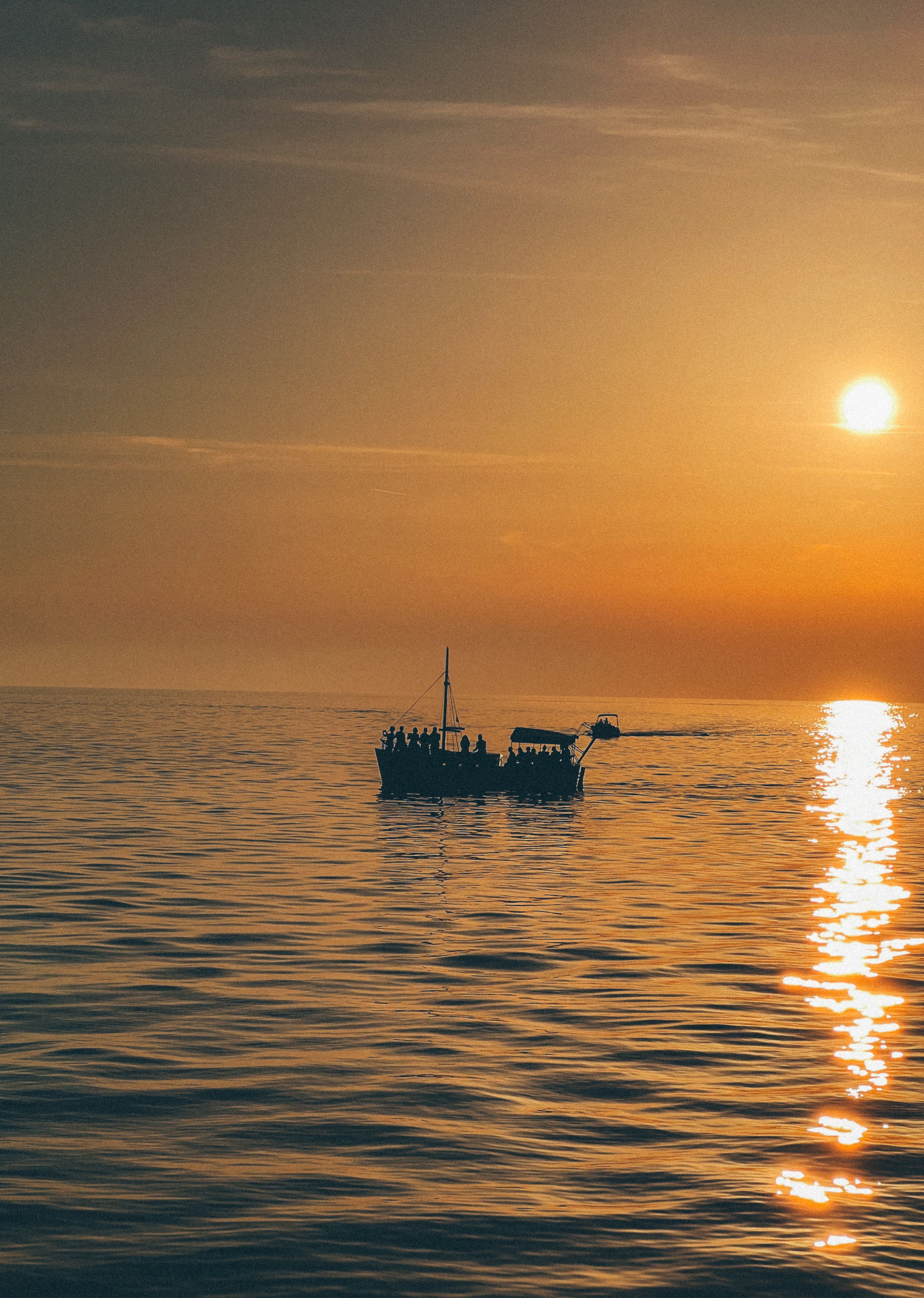 Silhouette of a Boat Sailing on the Sea at Sunset · Free Stock Photo
