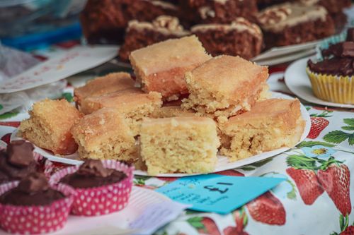 Free Appetizing lemon squares and cupcakes elegantly displayed at a bakery or market stand. Stock Photo