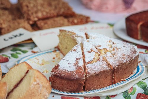 Free Close-up of a homemade sponge cake topped with powdered sugar on a table. Stock Photo