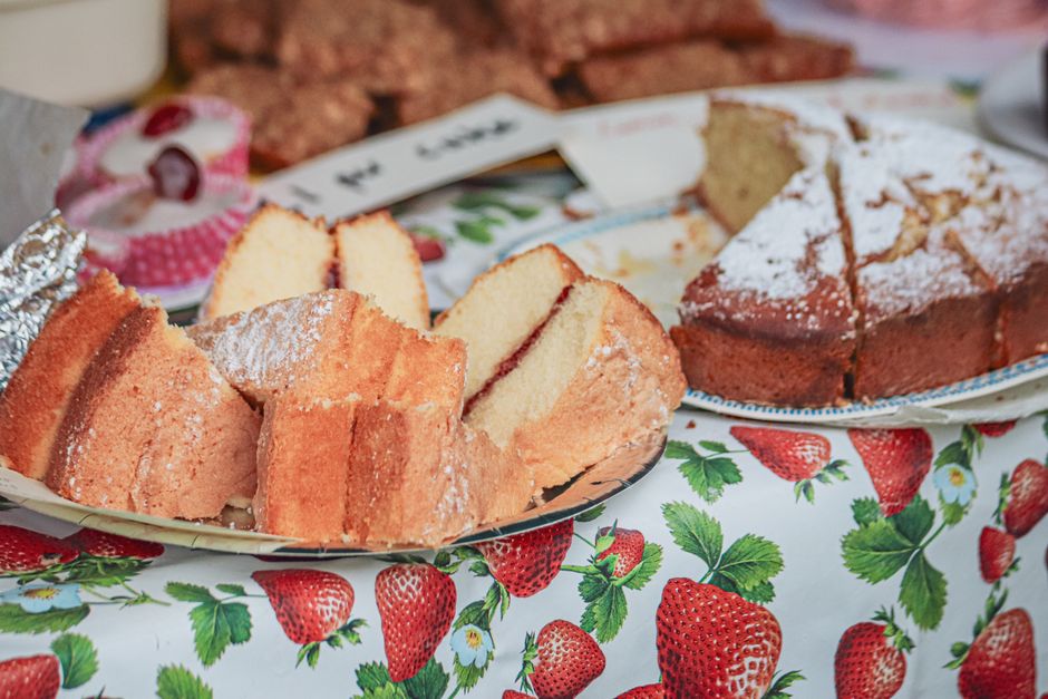 A sliced strawberry pound cake loaf on a wire rack, studded with diced strawberries and drizzled with a pale pink lemon glaze.