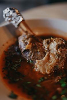 Delicious lamb shank beautifully presented in a rich, flavorful broth.