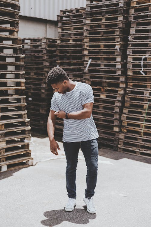 Man Standing Near Stack of Pallets