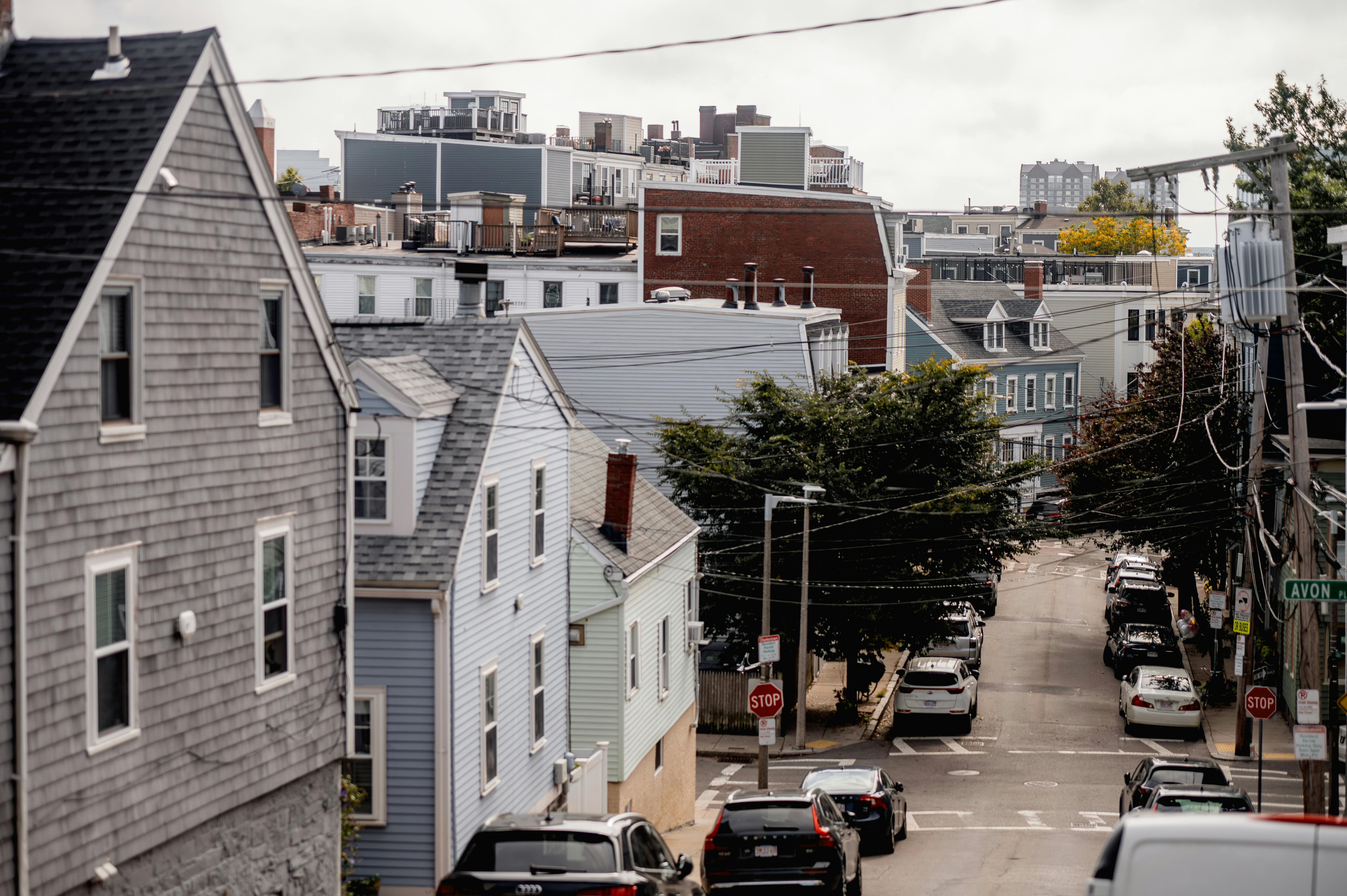 A scenic view of a residential neighborhood street with classic architecture and parked cars.