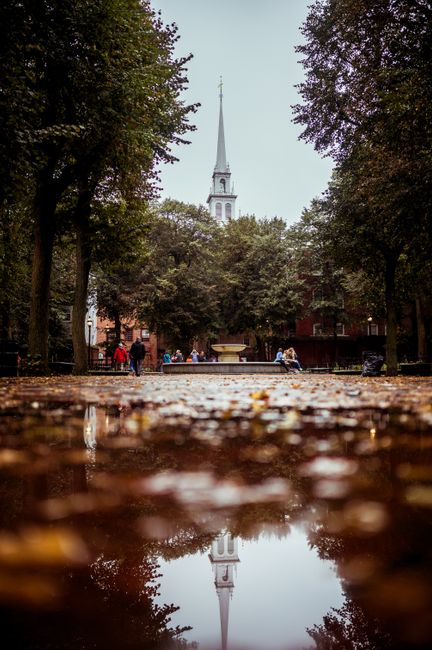 A rainy day reflection of the iconic Old North Church in Boston's historic park.