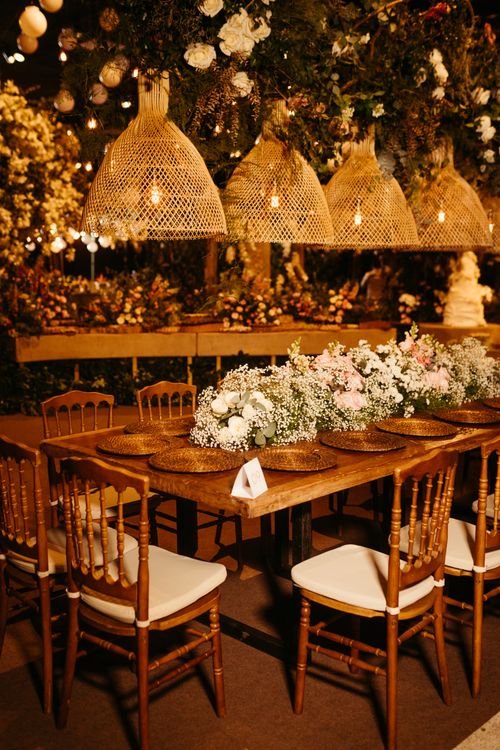 Free Stylish banquet setup featuring floral arrangements and wicker lighting in a warm indoor setting. Stock Photo