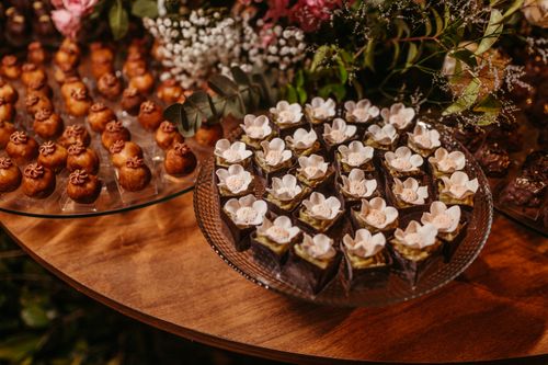 Free Sophisticated dessert arrangement featuring floral chocolates and pastries on a wooden table. Stock Photo