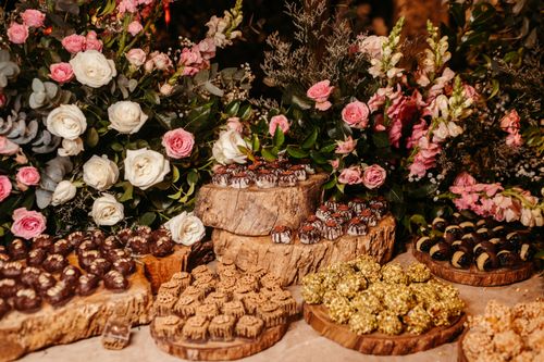 Free Beautiful arrangement of chocolates and flowers on wooden trays, perfect for elegant events. Stock Photo