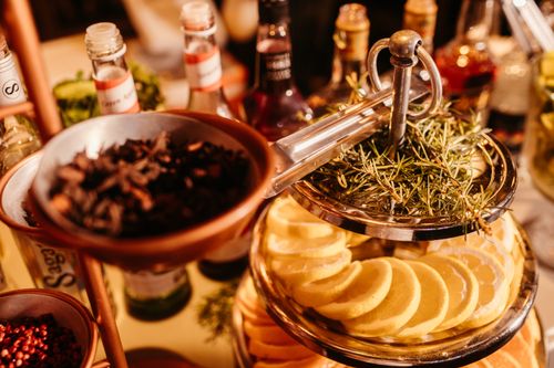 Free A vibrant bar display featuring bottles, spice garnishes, and lemon slices in a warm setting. Stock Photo