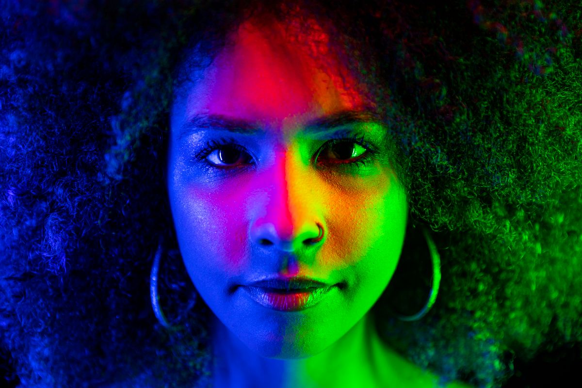 Close-up portrait lit by saturated coloured gels — photo by Oscar Calstrom on Pexels