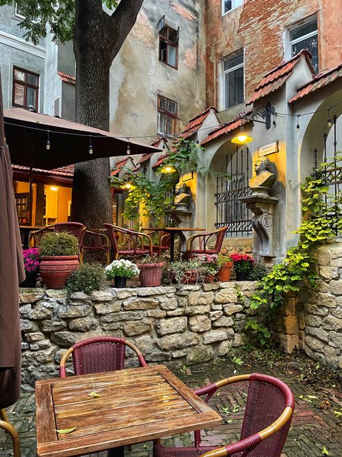 Free Cozy outdoor café with rustic charm and lush greenery in Lviv, Ukraine. Stock Photo