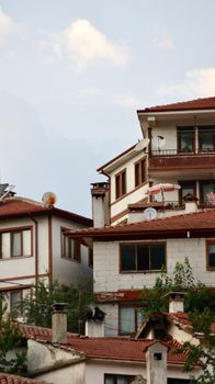 Traditional residential district with red-roofed houses and lush foliage.
