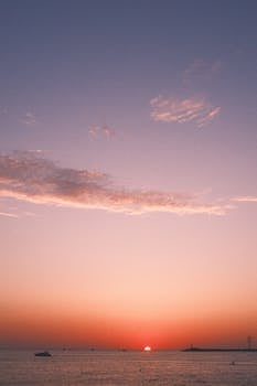 A stunning sunset over the ocean with vibrant colors and a calm seascape.