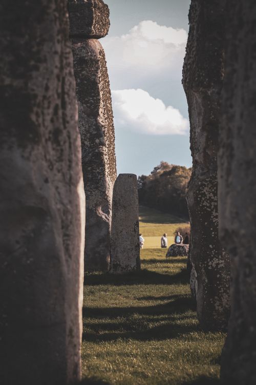 Free Stonehenge monoliths with people in the distance, captured on a clear day. Stock Photo