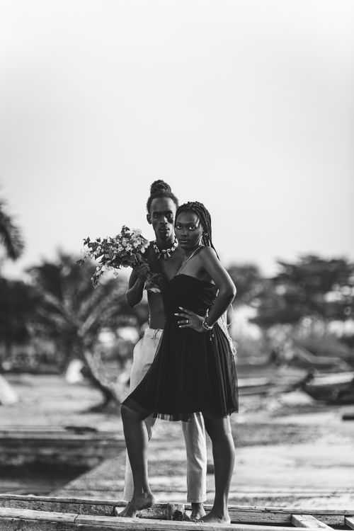 Free A couple poses outdoors holding a bouquet, embodying elegance and romance. Stock Photo