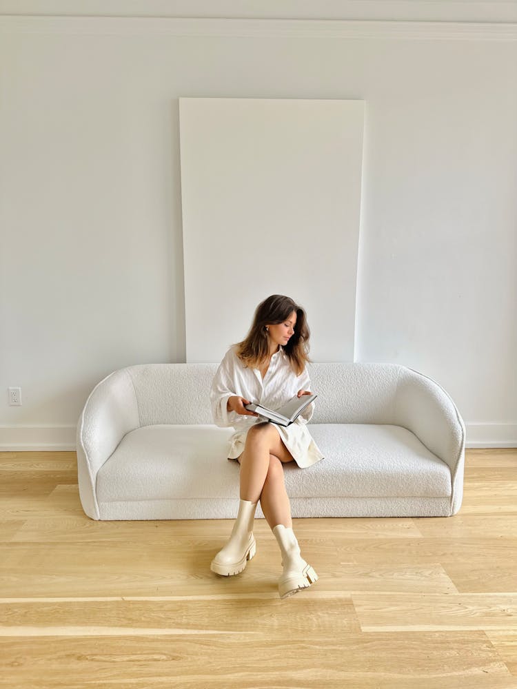 Woman In White Sits On White Sofa