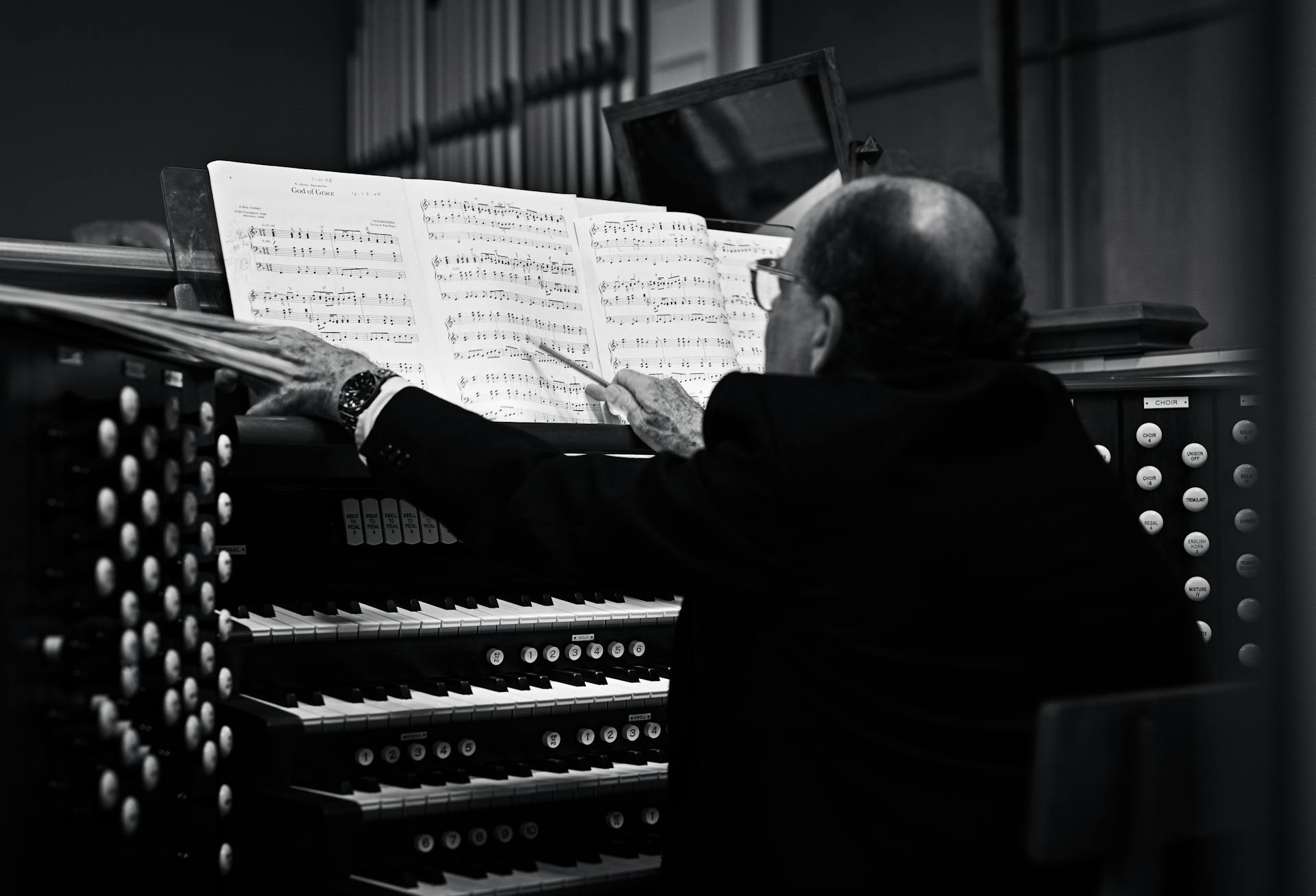 Man Sitting in front of the Organs and Reading the Notes