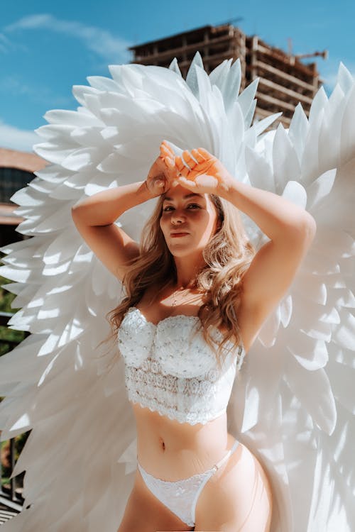 Young Woman Posing in White Lingerie and Wings 