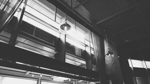 Grayscale Photo of Hanged Ceiling Lamp Inside the Building