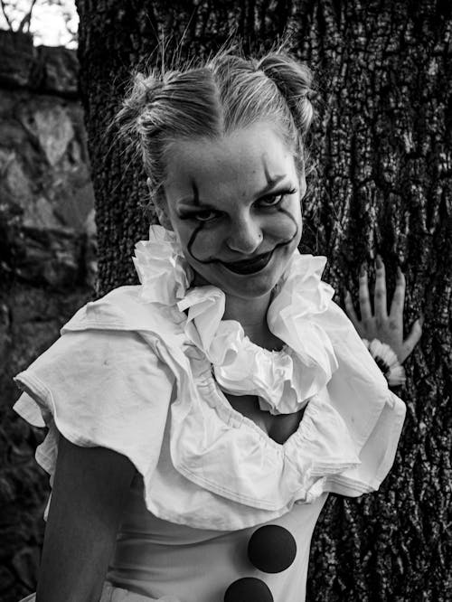 Black and White Photo of a Woman Dressed as a Clown 