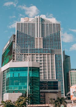 A striking modern skyscraper with unique architecture set against a clear blue sky in Panama City.