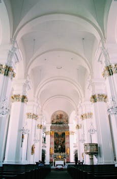 一座历史悠久的大教堂，其内饰奢华，以白色和金色为主，并配有华丽的枝形吊灯