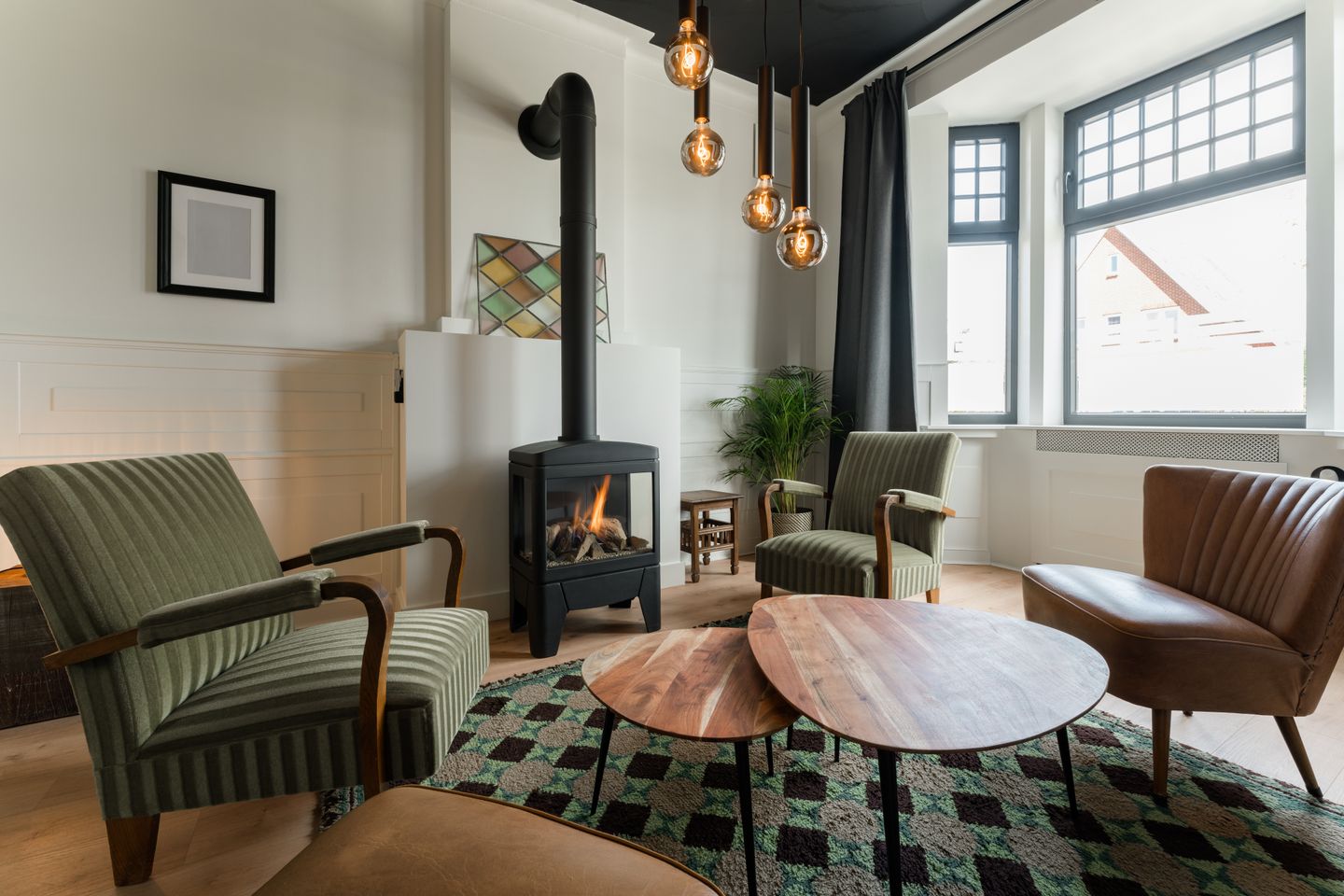 A wood-burner, two armchairs and good light: the sort of sitting room a well-made sofa is meant to end up in.