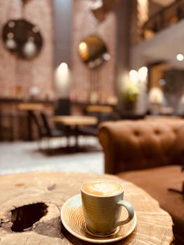 Aesthetic coffee cup with latte art on a rustic wooden table in a modern, stylish café.
