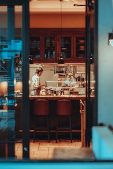 A chef preparing dishes in a modern Tokyo restaurant kitchen. Warm ambiance with elegant interior design.