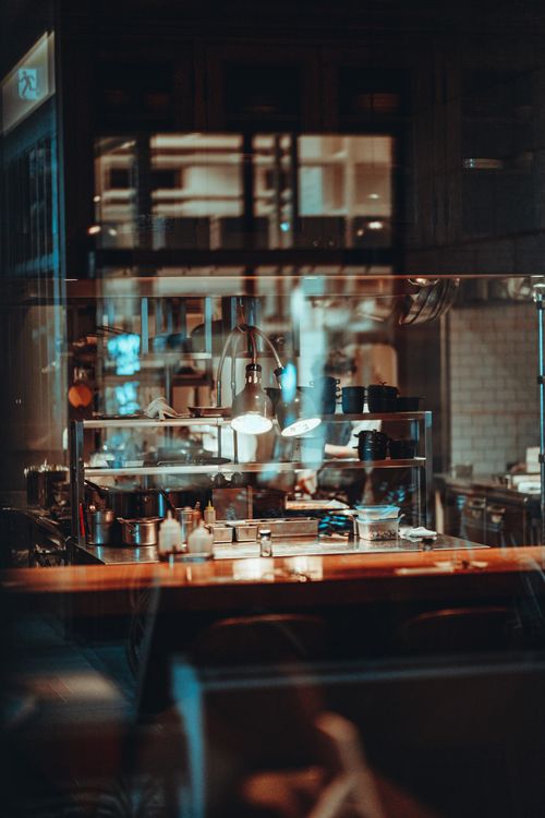 Free Warm café interior in Tokyo with wooden counter and ambient lighting, creating a cozy urban atmosphere. Stock Photo