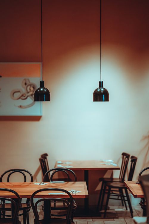 Free Warm minimalist café interior with wooden tables and pendant lights in Tokyo, Japan. Stock Photo