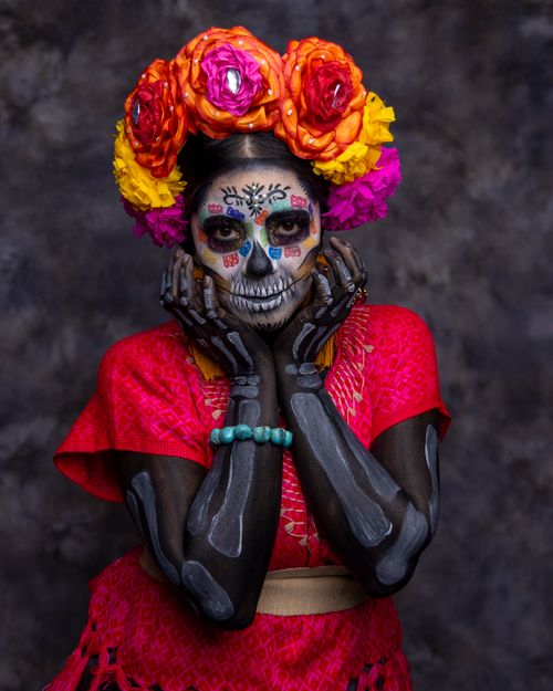 Free A colorful artistic makeup portrait celebrating Dia de los Muertos with traditional attire and floral crown. Stock Photo
