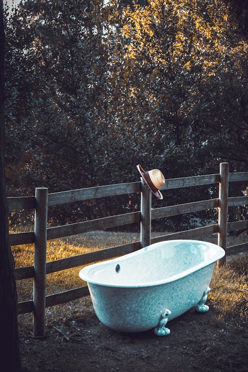 Bathtub by the Wooden Fence with a Hat