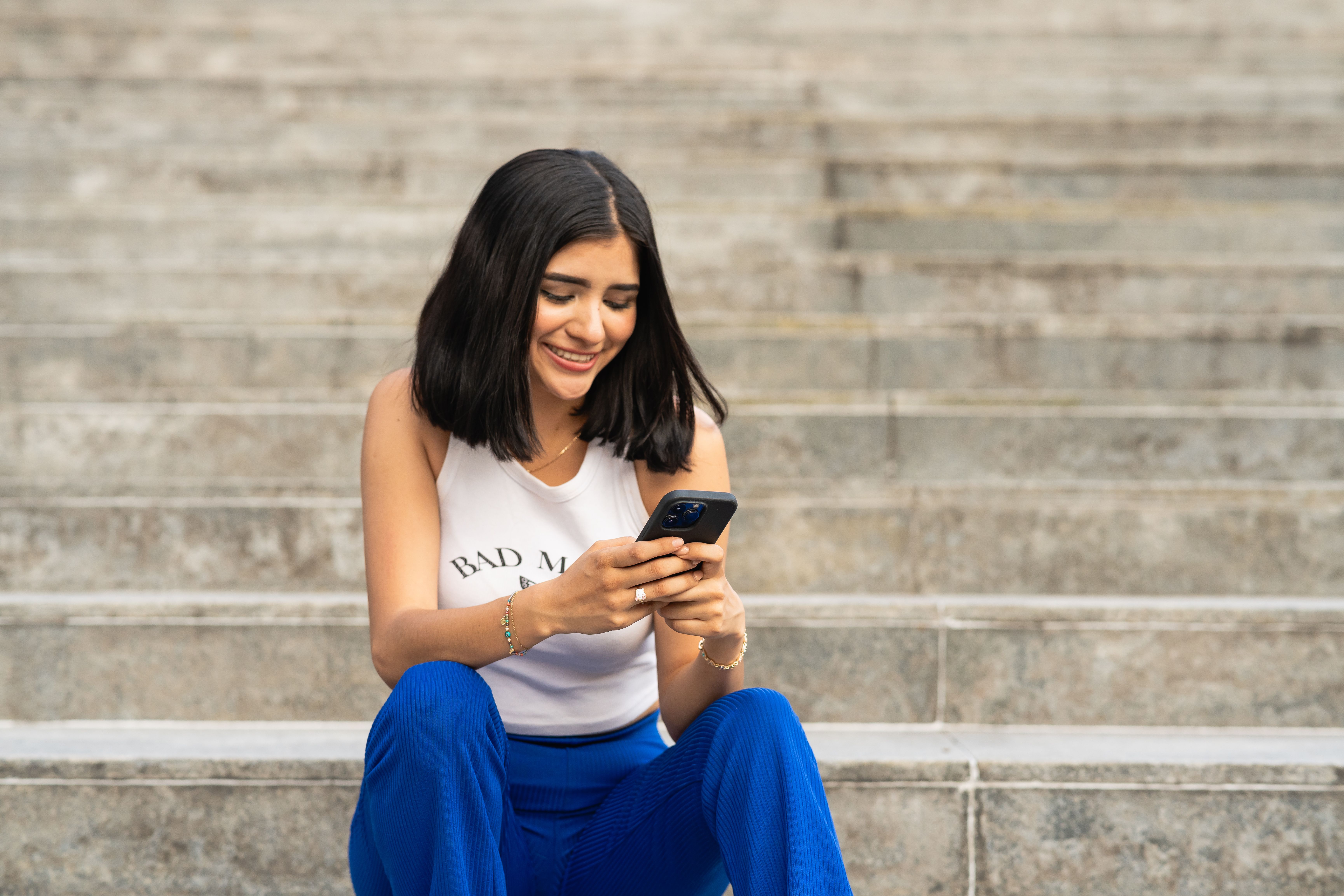 Mujer utilizando su teléfono en Ciudad de México mientras organiza sus finanzas