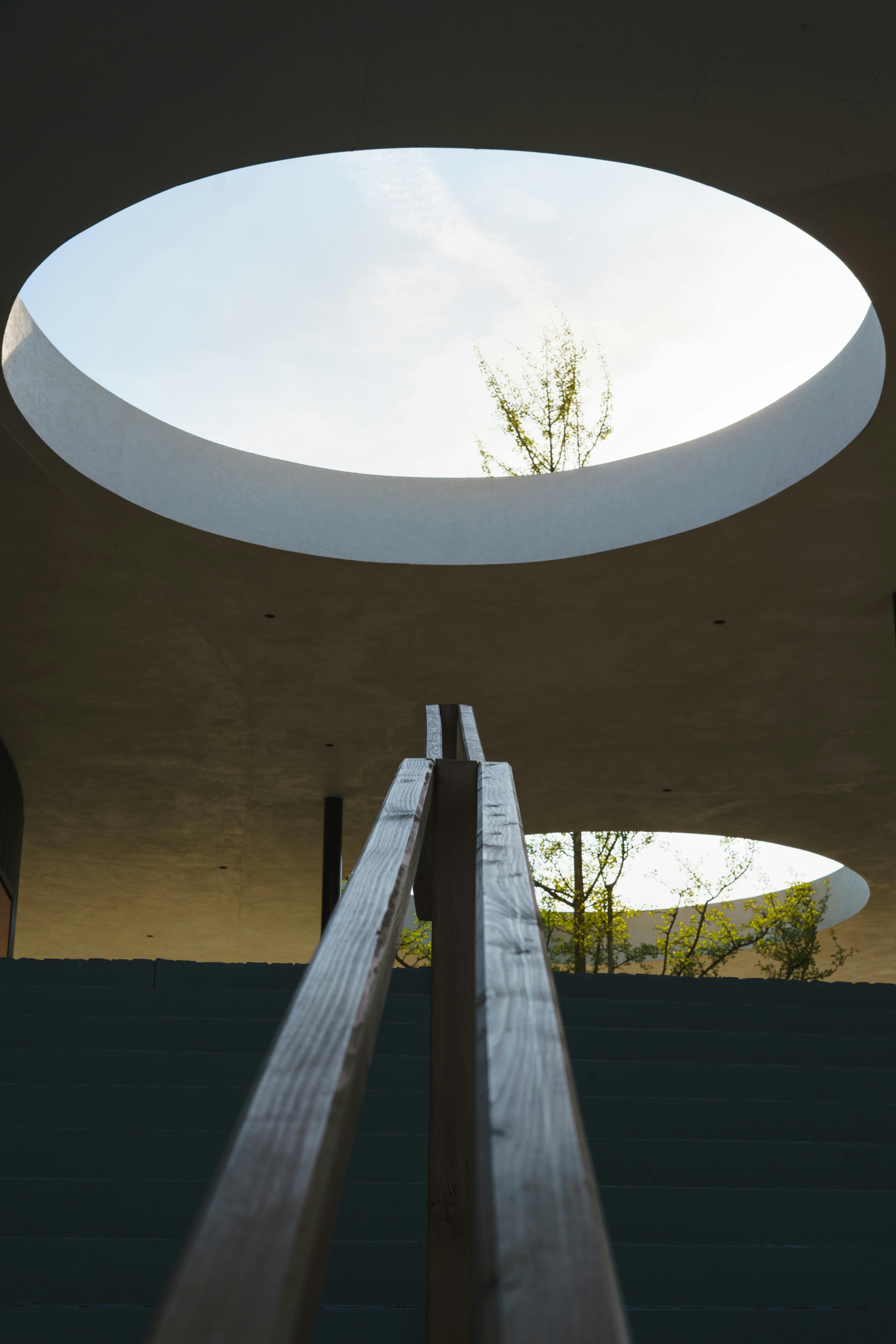 Stunning view of a modern atrium with large circular skylights and a minimalist design.
