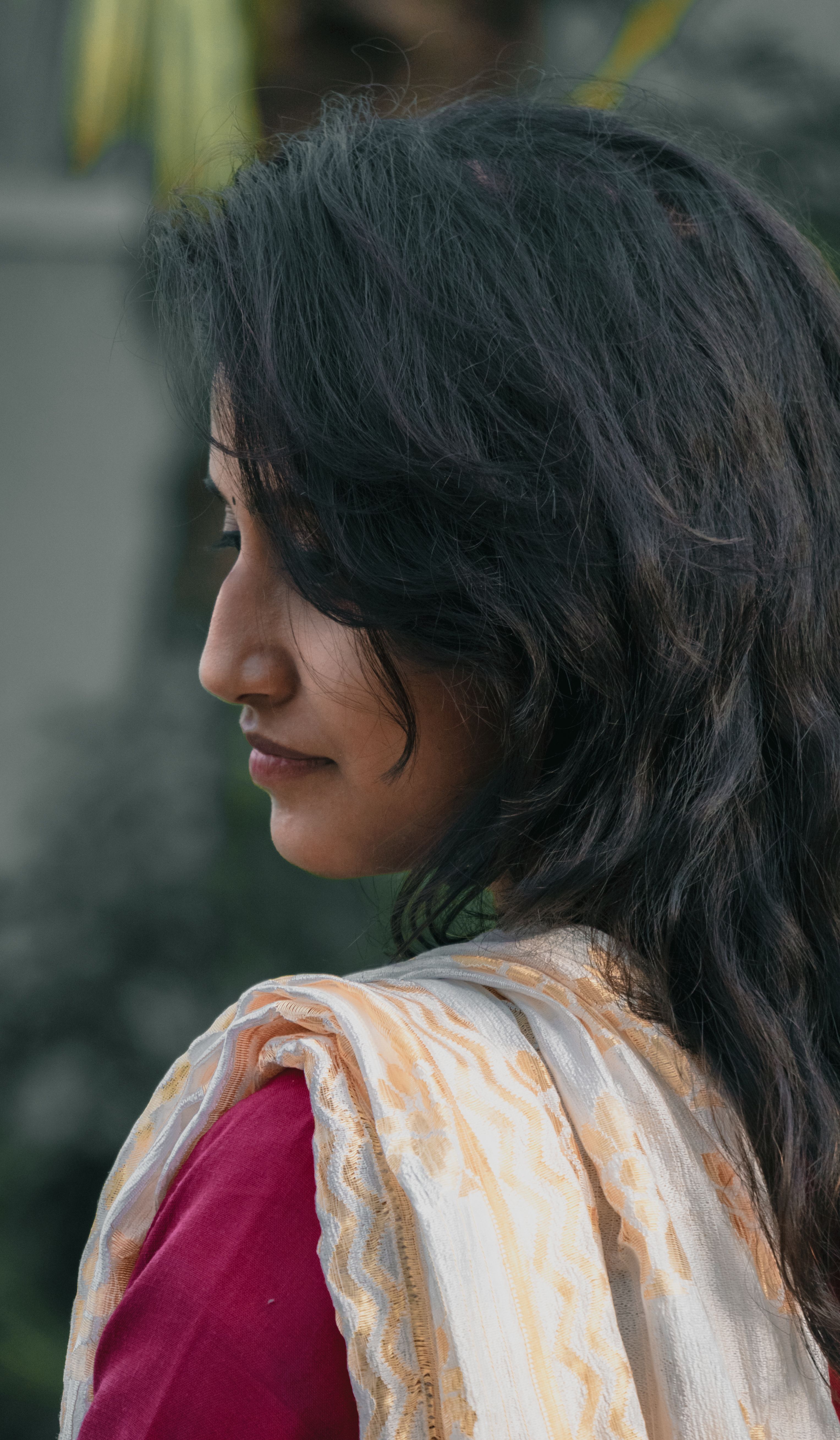 Side profile of a woman wearing a traditional saree, showcasing grace and natural beauty.