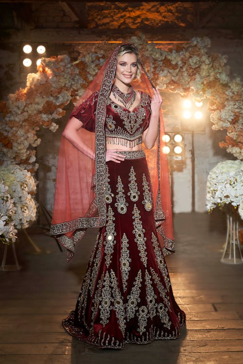 Woman Wearing a Burgundy Dress with Embroidery and a Veil 