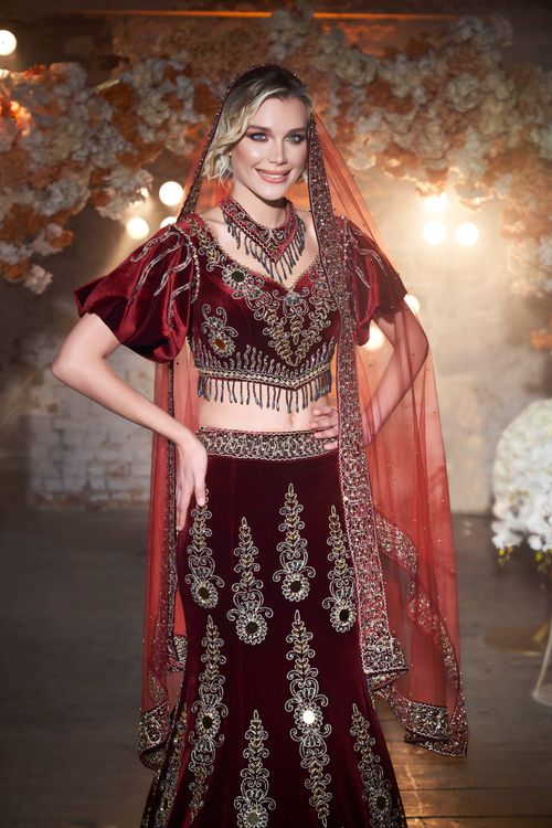 Free Woman in ornate traditional clothing posing indoors with a smile. Stock Photo