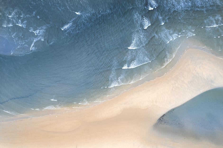 Stunning aerial shot of a beach and ocean waves, perfect for nature and travel content.