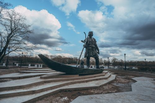 Free Statue of historical figure in boat at Gomel park, Belarus under a dramatic sky. Stock Photo