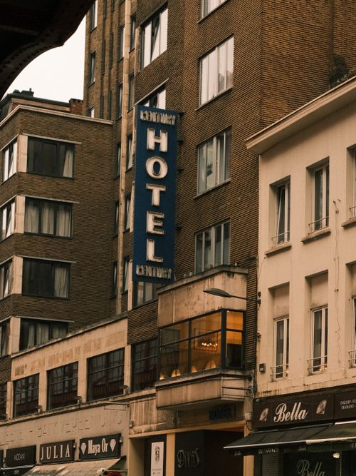 Free A street view of an urban hotel facade featuring a prominent blue sign. Stock Photo