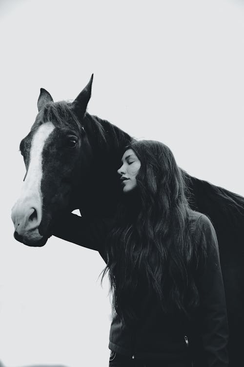 Woman Standing next to a Horse