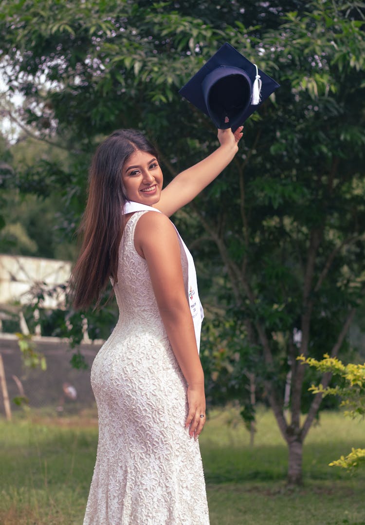 Smiling Graduate In White And With Academic Hat